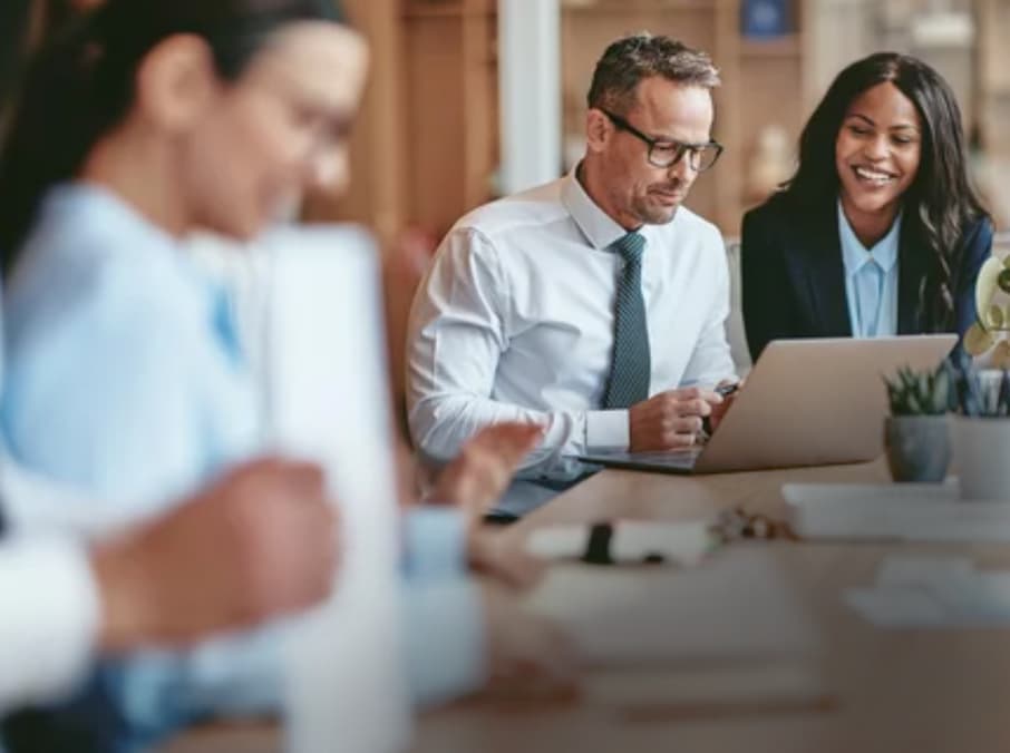 white woman, man and black woman at table in business meeting