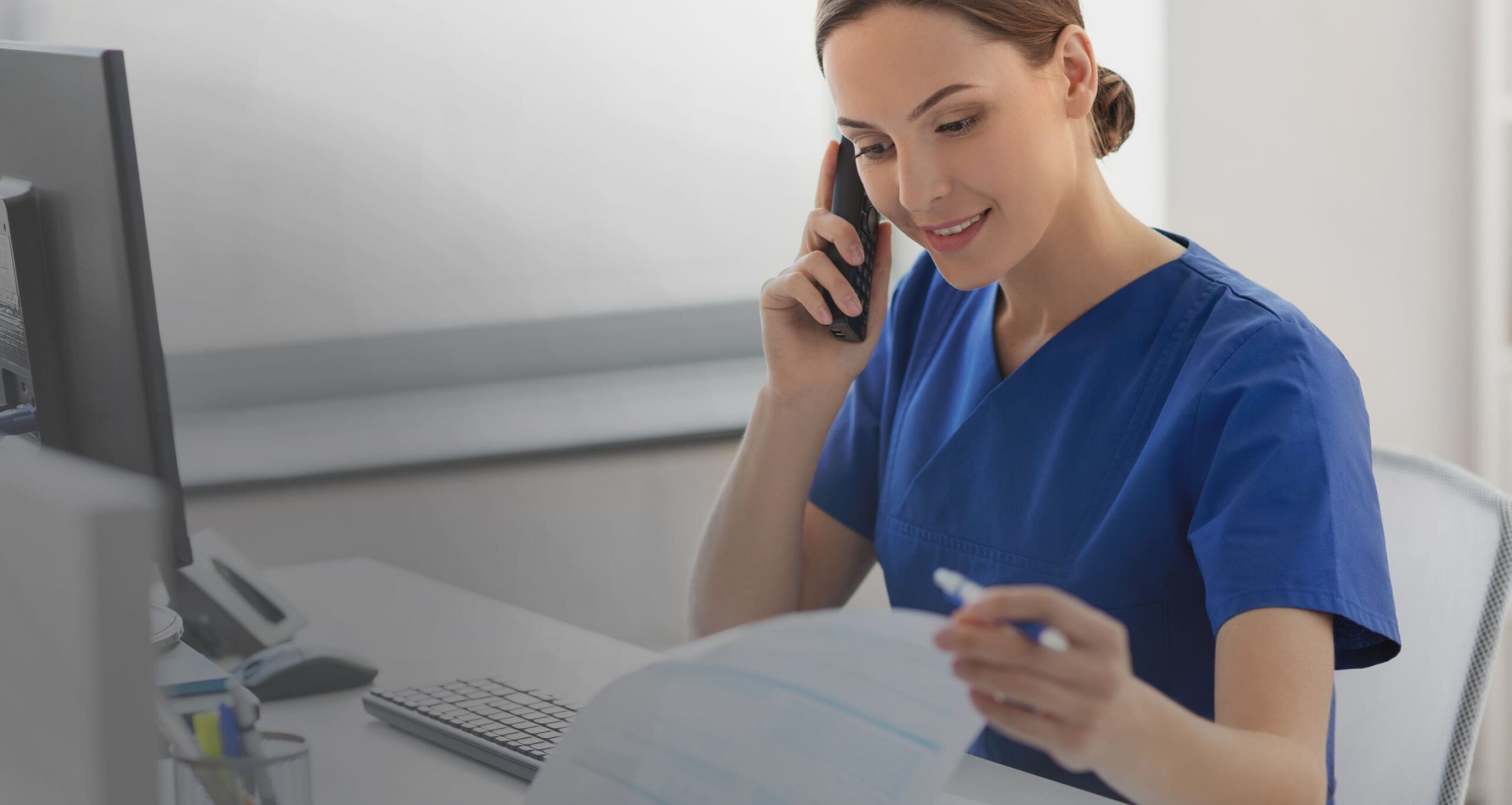 medical practice office worker on phone viewing medical billing