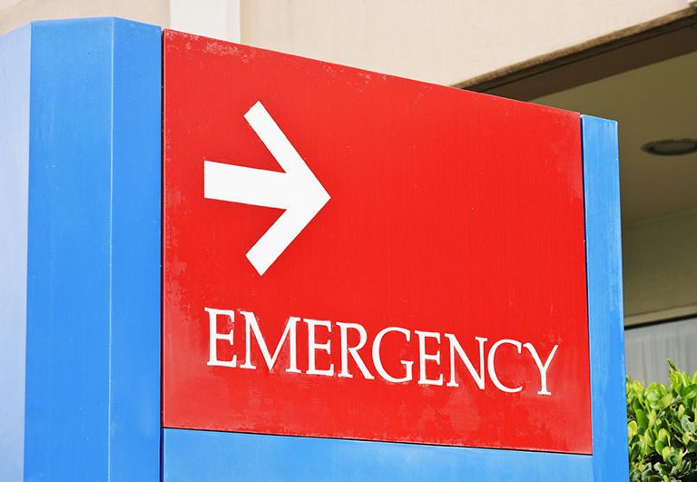 sign at the hospital points towards the emergency room entrance.